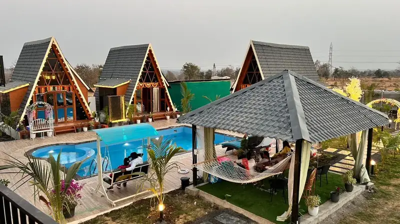 Guests relaxing by the gazebo and pool at dusk