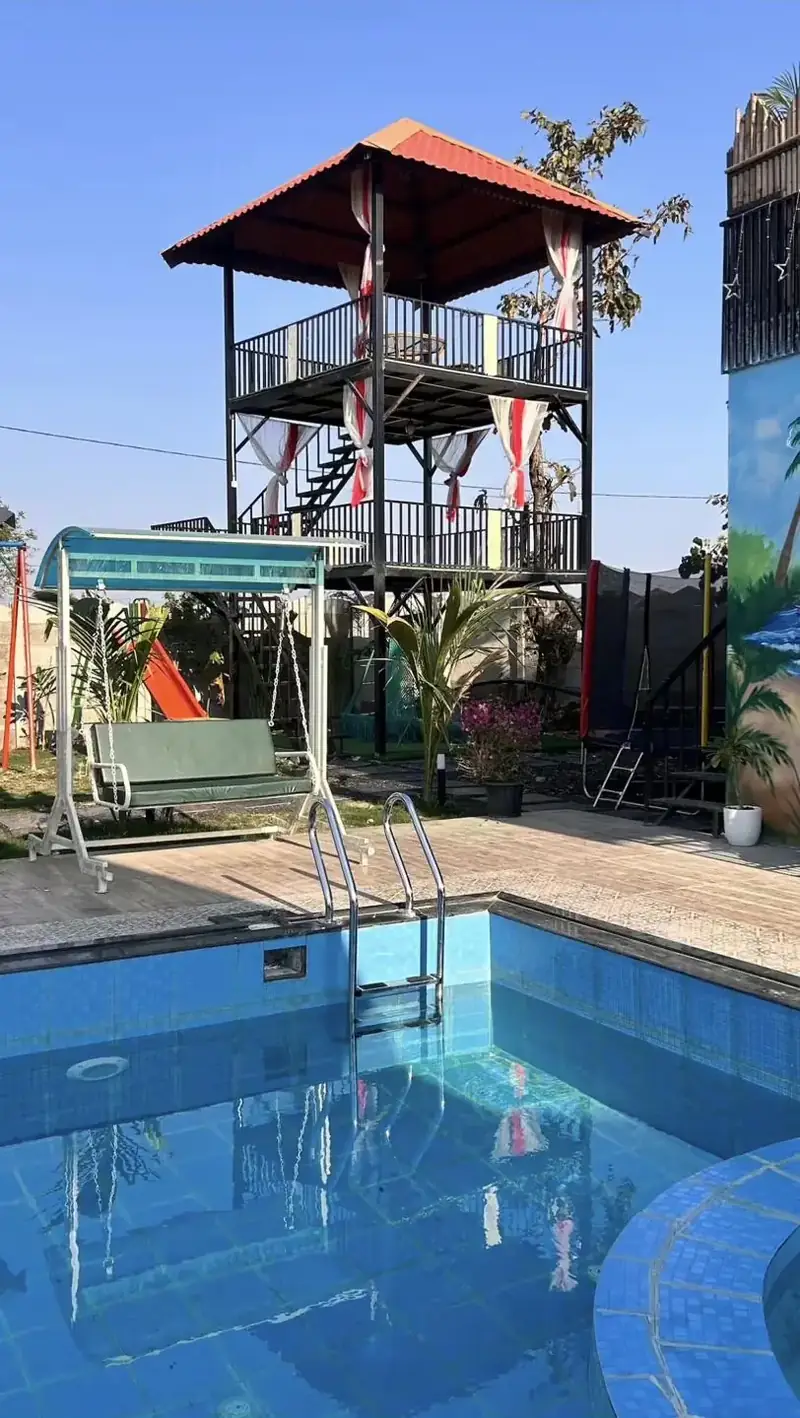 Two-level machan with a red roof beside the pool