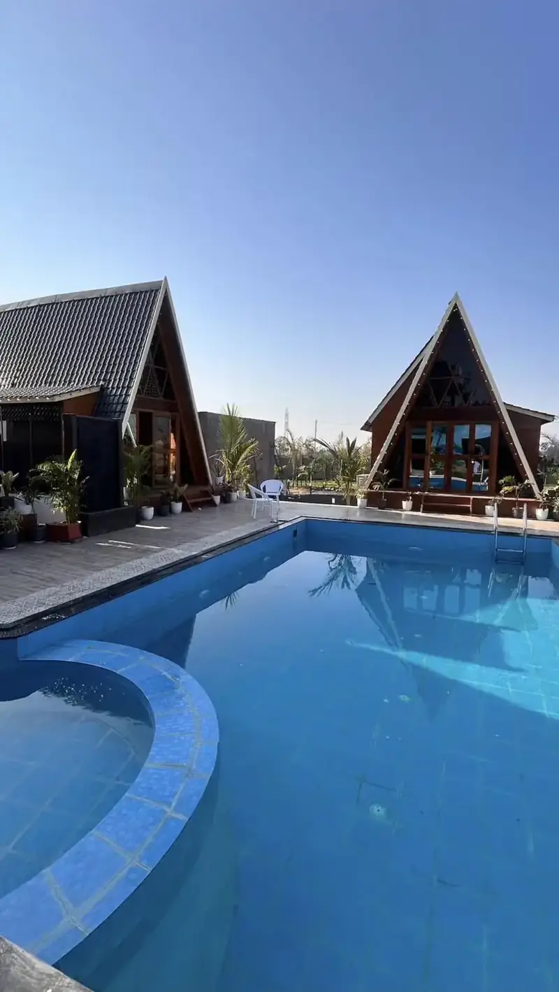 The pool and two A-frames under a clear sky